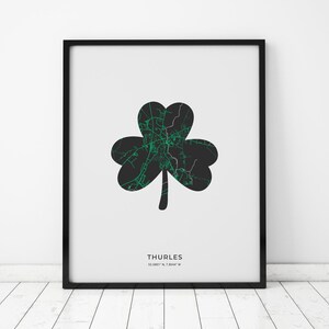 Puede incluir: Una impresión en forma de trébol en blanco y negro con un contorno verde de la ciudad de Thurles, Irlanda. La impresión incluye las coordenadas 52.6801° N, 7.8044° W. La impresión está enmarcada en un marco negro.