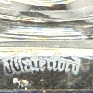 May include: Close-up of a clear glass object with a textured surface. The word "JUST" is visible in a stylized font. The object appears to be a decorative piece.
