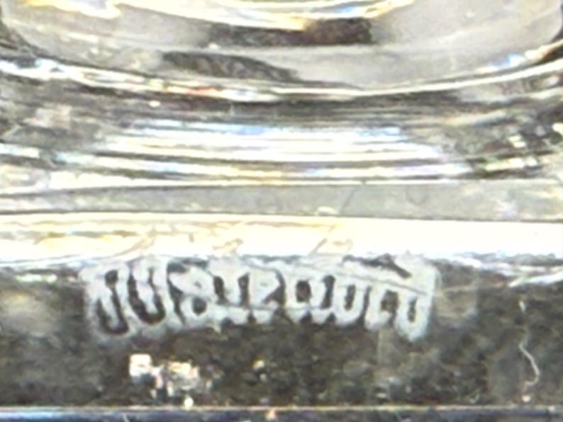 May include: Close-up of a clear glass object with a textured surface. The word "JUST" is visible in a stylized font. The object appears to be a decorative piece.