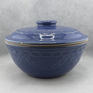 Peut inclure: Un bol en céramique bleu avec un couvercle assorti. Le bol présente un motif de chaîne décoratif sur les côtés. Le couvercle a une petite poignée et un bord décoratif. Le bol est de couleur bleu uni.