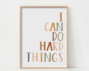 Puede incluir: Una impresión enmarcada con el texto "I CAN DO HARD THINGS" en una variedad de colores, incluyendo marrón, naranja, rosa y verde.