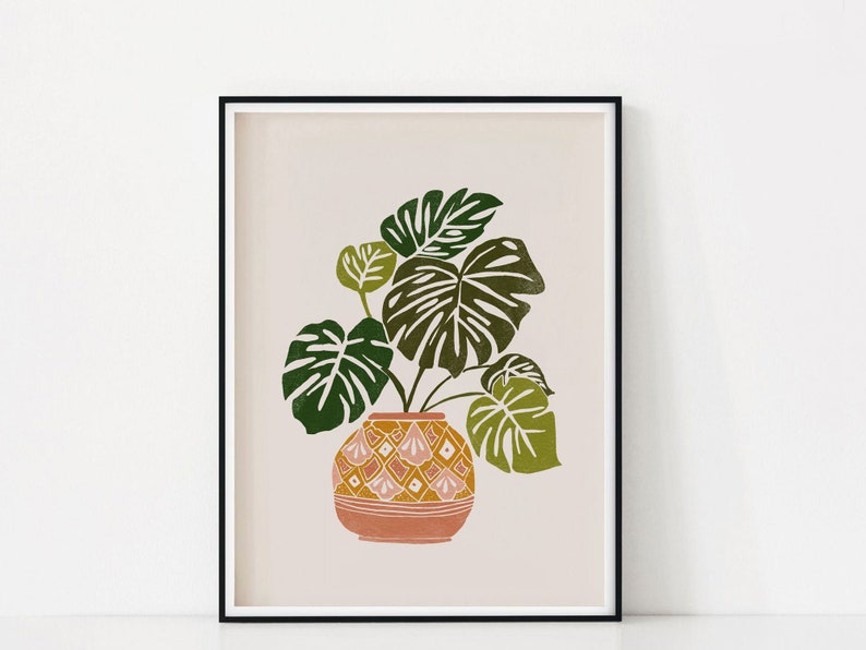 May include: A print of a green and yellow tropical plant in a pink and yellow patterned pot on a light beige background.