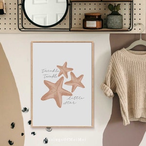 May include: A beige framed print with a white background featuring three pink starfish and the text "Twinkle Twinkle Little Star".