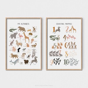May include: Two educational posters with a light wood frame. The left poster features an alphabet chart with animals and the text "My Alphabets". The right poster features a counting chart with animals and the text "Counting Animals".
