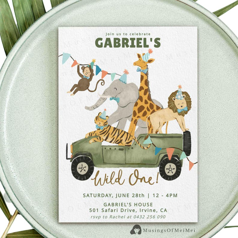 May include: A rectangular birthday invitation card featuring a green safari jeep carrying a tiger, elephant, giraffe, lion, and monkey wearing party hats. Text reads: Join us to celebrate GABRIEL'S Wild One! SATURDAY, JUNE 28th | 12 - 4PM 501 Safari Drive, Irvine, CA rsvp to Rachel at 0432 256 090.
