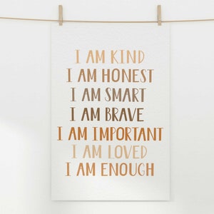 May include: A white poster with the words "I AM KIND, I AM HONEST, I AM SMART, I AM BRAVE, I AM IMPORTANT, I AM LOVED, I AM ENOUGH" printed in various shades of brown. The poster is hanging from a clothesline with a wooden clip.