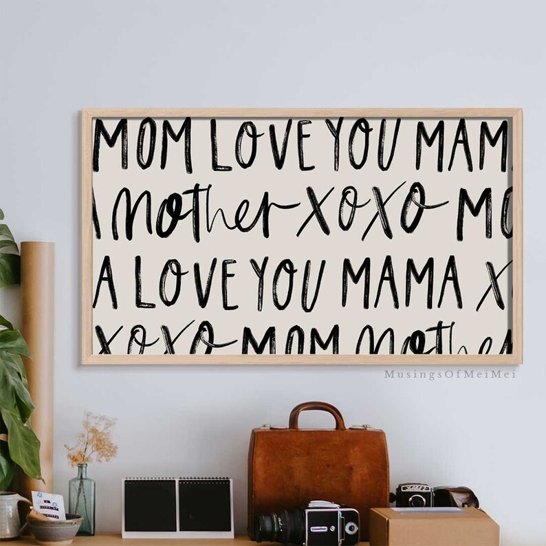 May include: A framed print with a beige background and black text that reads "MOM LOVE YOU MAM Mother Xoxo MO A LOVE YOU MAMA X XOXO MOM Mother".