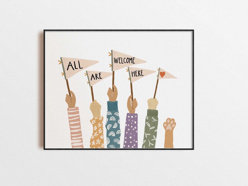 May include: A framed art print featuring raised arms holding pennant flags. The flags read "ALL ARE WELCOME HERE" with a heart symbol. The arms have various sleeve patterns, including stripes, florals, and leaves. The artwork is set against a white background.