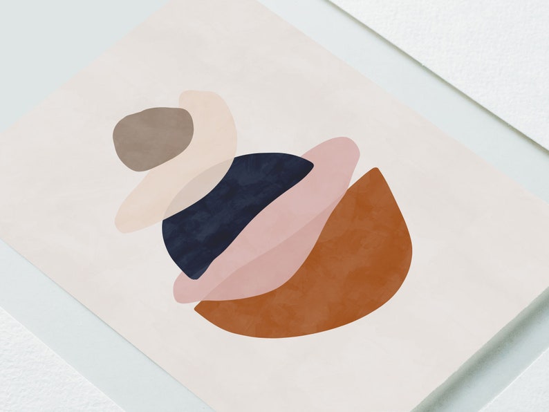 K&ouml;nnte beinhalten: Abstrakter Kunstdruck mit geschichteten Formen in ged&auml;mpften T&ouml;nen. Das Design umfasst einen dunkelblauen Kreis, einen rostfarbenen Halbmond und sich &uuml;berlappende Formen in Rosa, Beige und Braun auf cremefarbenem Hintergrund.