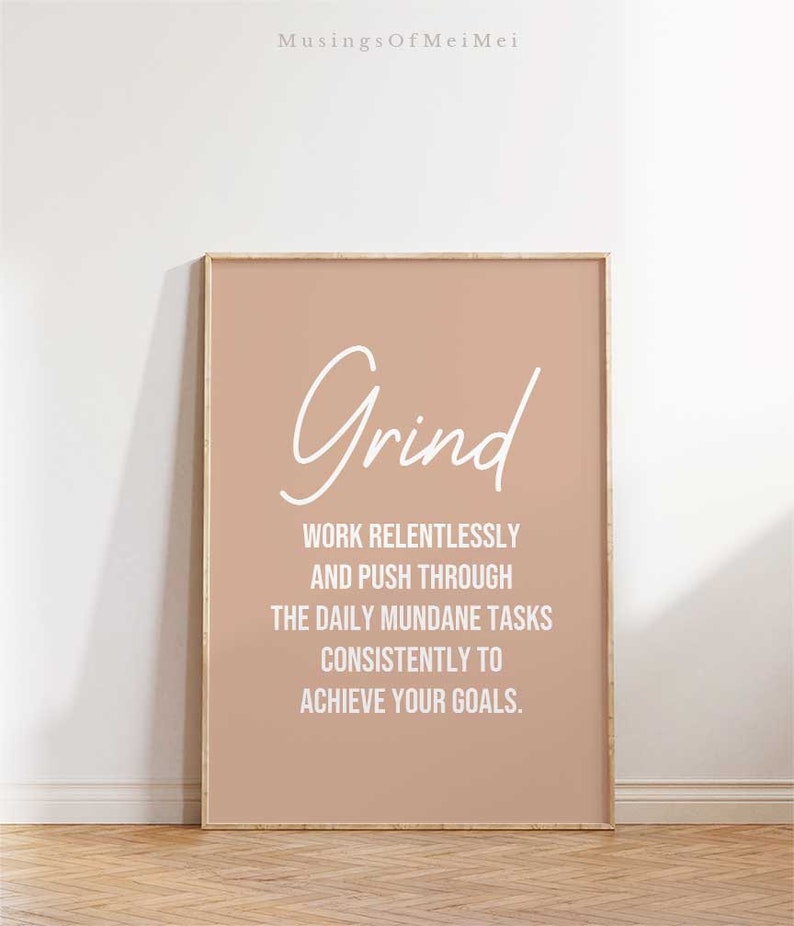 May include: A motivational poster with a peach background and white text that reads "Grind" and "Work relentlessly and push through the daily mundane tasks consistently to achieve your goals."