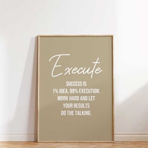 May include: A beige framed print with the text "Execute" in white cursive script. The text below reads "Success is 1% idea, 99% execution. Work hard and let your results do the talking."