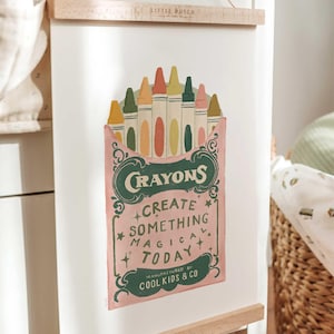 Puede incluir: Una ilustraci&oacute;n de estilo vintage de una caja de crayones con el texto "Crayons", "Crea algo m&aacute;gico hoy" y "Fabricado por Cool Kids & Co."