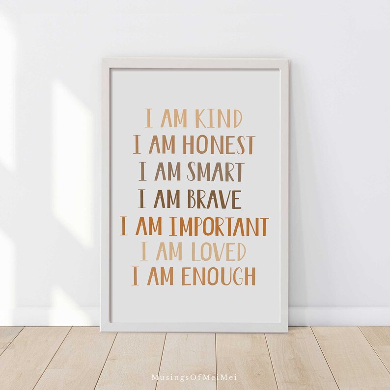 May include: A framed print with the words "I AM KIND, I AM HONEST, I AM SMART, I AM BRAVE, I AM IMPORTANT, I AM LOVED, I AM ENOUGH" in various shades of brown. The print is in a white frame and is displayed against a white wall.