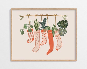 May include: Five red and white Christmas stockings are hanging from a string with different plants growing out of the top of each stocking.