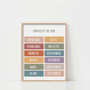May include: A printable chart with the months of the year in a colorful, rectangular grid. Each month is written in white text on a different colored rectangle. The chart is framed in a light wood frame.