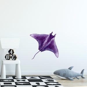 May include: A purple watercolor illustration of a manta ray, a type of fish, with a long tail and large wing-like fins. The illustration is on a white background.