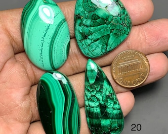 Puede incluir: Cuatro piedras preciosas de malaquita pulida etiquetadas 17, 18, 19 y 20, con distintos patrones verdes de bandas y radiales. Se incluye una moneda de un centavo de EE. UU. para comparar el tamaño, y el texto Q-878 es visible abajo a la derecha.