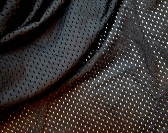 May include: Black mesh fabric with a diamond pattern. The fabric is wrinkled and has a slight sheen.