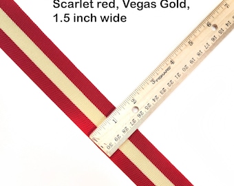 May include: A red and gold striped ribbon measuring 1.5 inches wide. The ribbon is being measured with a ruler.