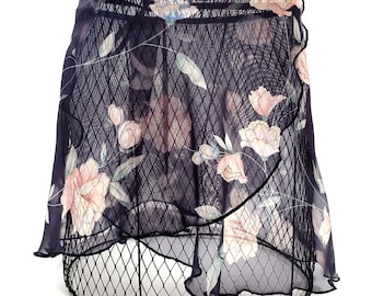 May include: A black sheer skirt with a floral print. The skirt has a ruffled hem and is made of a lightweight fabric.