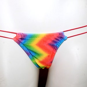 May include: Rainbow tie-dye bikini bottom with thin red straps.