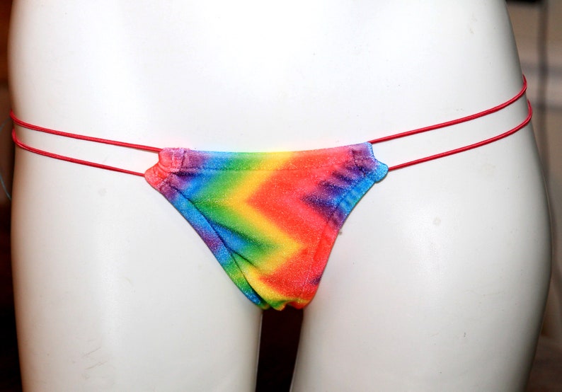 May include: Rainbow tie-dye bikini bottom with thin red straps.