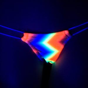 May include: A neon pink, orange, blue, and green striped thong with a black elastic waistband.