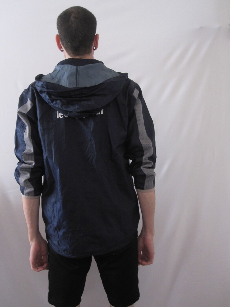 May include: A navy blue hooded jacket with gray accents and a white logo that says "Lee Cooper".