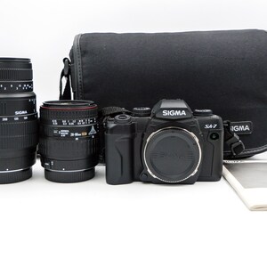 Sigma SA-7 Autofocus SLR Camera with Sigma 28-80mm and Sigma 70-300mm lenses, in original Sigma Case. Everything is in MINT+ Condition