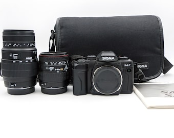 Sigma SA-7 Autofocus SLR Camera with Sigma 28-80mm and Sigma 70-300mm lenses, in original Sigma Case. Everything is in MINT+ Condition