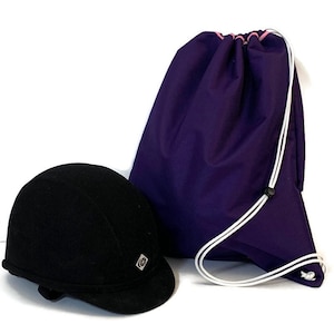 May include: A black riding helmet with a white logo and a purple drawstring bag with a pink trim.