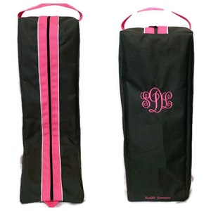 May include: A black boot bag with pink accents and a zipper closure. The bag has a handle and is monogrammed with the letters "SLL". The text "Saddle Jummies" is printed on the bottom of the bag.