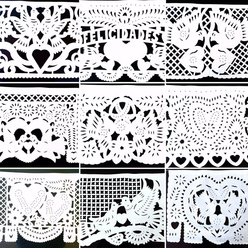 May include: Nine white paper banners with intricate cut-out designs, including hearts, flowers, birds, and the word "FELICIDADES". The banners are arranged in a grid pattern against a black background.