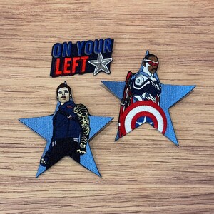 May include: Embroidered patches featuring characters from a superhero franchise. One patch reads "ON YOUR LEFT" with a star. Two star-shaped patches depict characters, one with a shield design and the other with a metal arm.