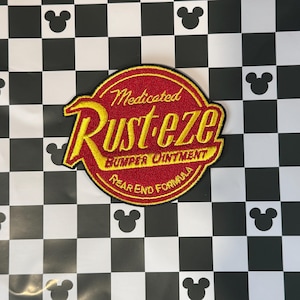May include: A red and gold embroidered patch with the text "Medicated Rust-eze Bumper Ointment Rear End Formula".