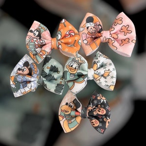 Può includere: Una collezione di sette fiocchi per capelli in tessuto con vari disegni di personaggi Disney. I fiocchi presentano personaggi come Topolino, Minnie e Paperino, con motivi e colori festosi. Ogni fiocco è un design unico, perfetto per aggiungere un tocco di magia Disney.