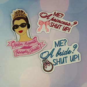 Puede incluir: Parches bordados con frases e imágenes humorísticas. Uno presenta a una mujer con gafas de sol y una corona. Otros dicen "¿Yo? ¿Una princesa? ¡Cállate!" y "¿Yo? ¿Una novia? ¡Cállate!" en rosa y azul.