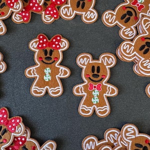 Peut inclure: Ornements en feutre en forme de bonhomme en pain d'épices marron avec des détails de glaçage blanc. L'un a un nœud rouge à pois blancs, l'autre un nœud papillon rouge. Les deux ont des accents verts et blancs. Décorations de vacances festives.