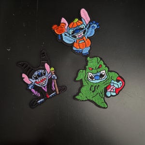 May include: Three embroidered iron-on patches featuring Stitch from Lilo & Stitch. The first patch shows Stitch dressed as a pumpkin, the second shows Stitch dressed as a vampire, and the third shows Stitch dressed as a ghost.