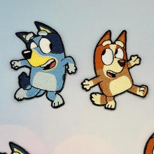 Puede incluir: Parches bordados con personajes de dibujos animados en tonos azules, marrones y beige. Los parches muestran a los personajes en una pose de carrera con la boca abierta y expresiones emocionadas. Los parches son probablemente para ropa o accesorios.