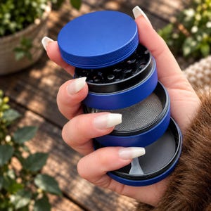 May include: A four-piece blue herb grinder with a textured lid, a black interior grinding chamber with sharp teeth, a fine metal mesh screen for sifting, and a solid bottom collection compartment, all stacked vertically in a handheld arrangement.
