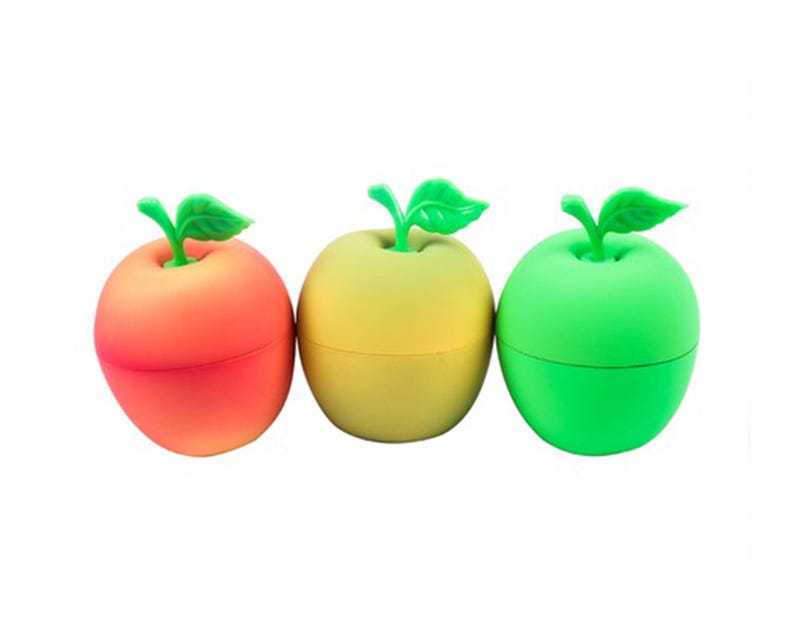 May include: Three apple-shaped containers, each with a green stem and leaf. The containers are in red, yellow, and green. These containers are likely for storing small items or as decorative pieces.