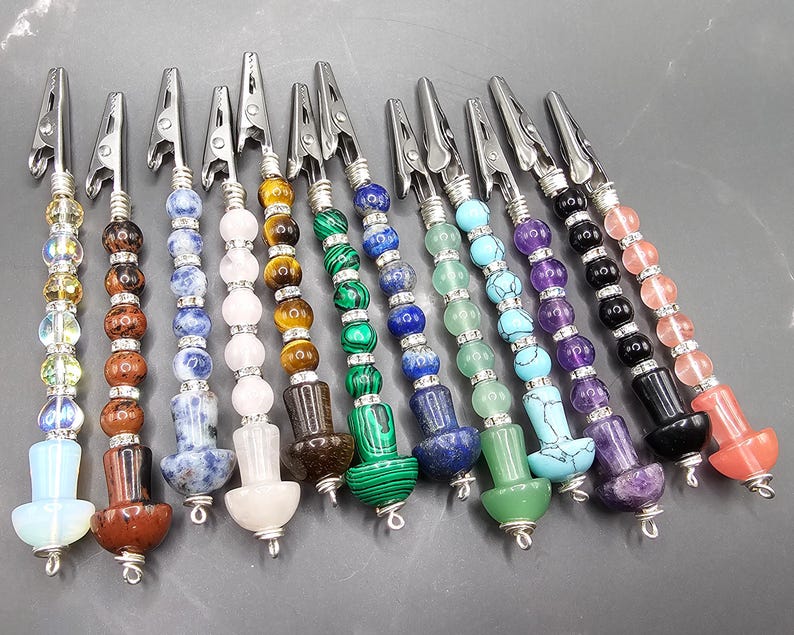 May include: Twelve colorful beaded hair clips with metal clips. Each clip has a different color and pattern of beads, including blue, green, red, purple, and white.