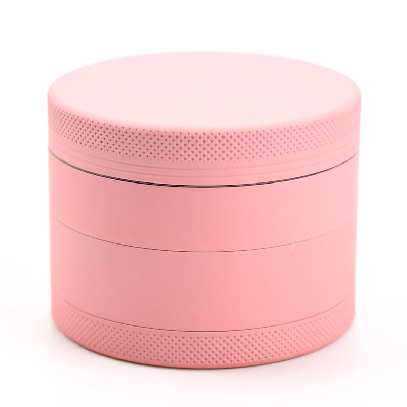 May include: A four-piece pink metal grinder with a textured top and bottom.