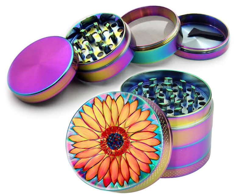 May include: A four-piece metal grinder with a sunflower design on the top. The grinder has a rainbow iridescent finish.