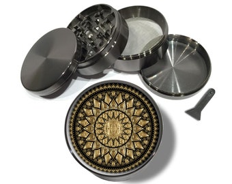 May include: A four-piece metal grinder with a gold mandala design on the bottom piece. The grinder has a screen, a herb chamber, and a top piece with teeth.