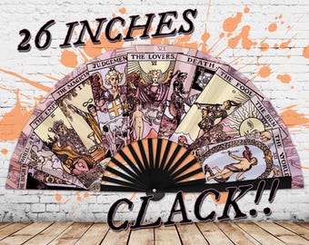 May include: A 26-inch folding fan with a black handle and a colorful design featuring tarot cards. The fan is open and the cards are visible. The text "CLACK!" is printed on the bottom of the fan.