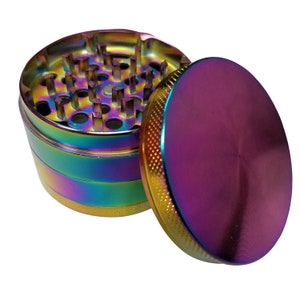 May include: A multi-colored metal grinder with a round, iridescent top. The grinder has a series of teeth for grinding herbs and a compartment for collecting the ground herbs.