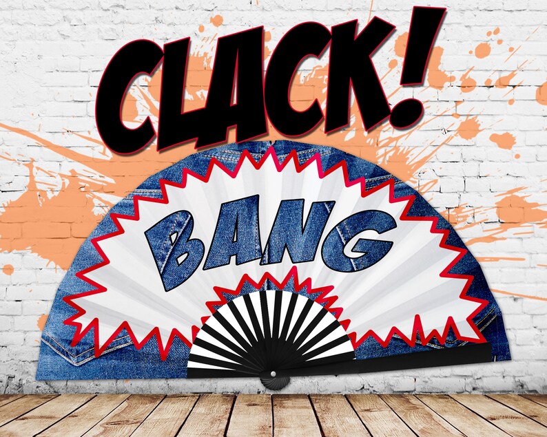 May include: A denim fan with a white and red burst design, featuring the word "BANG" in blue letters. The word "CLACK!" is written above the fan in black. The background includes a white brick wall with orange paint splatters.