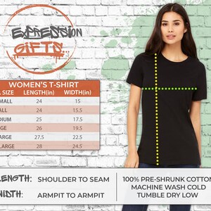 Puede incluir: Una tabla de tallas para camisetas de mujer con medidas en pulgadas. La tabla muestra la longitud y el ancho de las camisetas en diferentes tallas, desde XS hasta XXL. El texto debajo de la tabla dice "LENGTH: SHOULDER TO SEAM" y "WIDTH: ARMPIT TO ARMPIT". El texto debajo de eso dice "100% PRE-SHRUNK COTTON MACHINE WASH COLD TUMBLE DRY LOW".